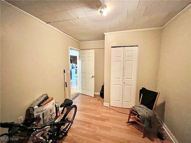 living area with hardwood / wood-style floors and ornamental molding