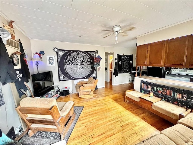 living room featuring ceiling fan, crown molding, and light hardwood / wood-style floors