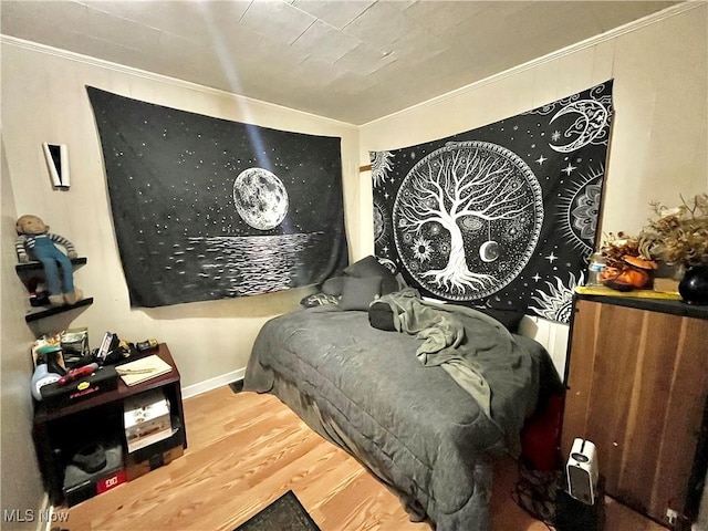 bedroom featuring hardwood / wood-style floors and crown molding