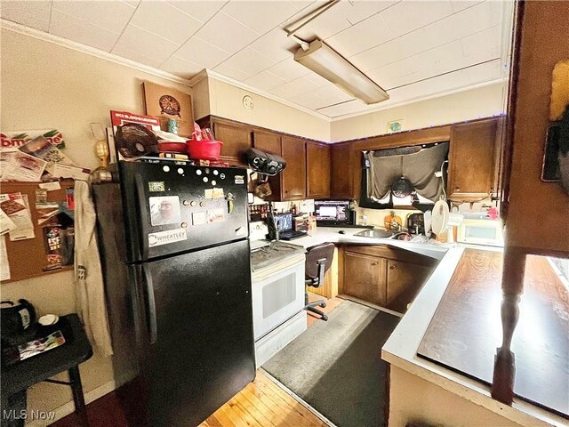 kitchen with white appliances, crown molding, and sink