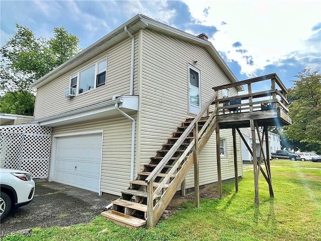 view of side of home featuring a lawn, a wooden deck, cooling unit, and a garage