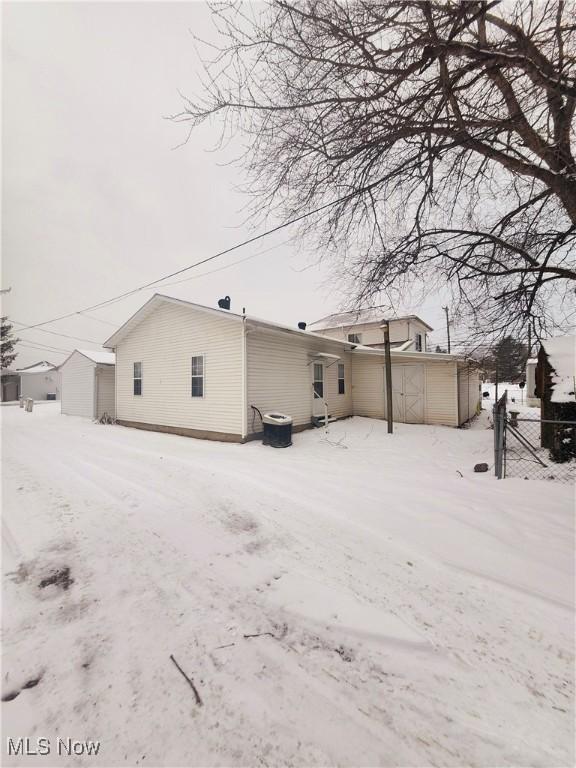 view of snow covered rear of property