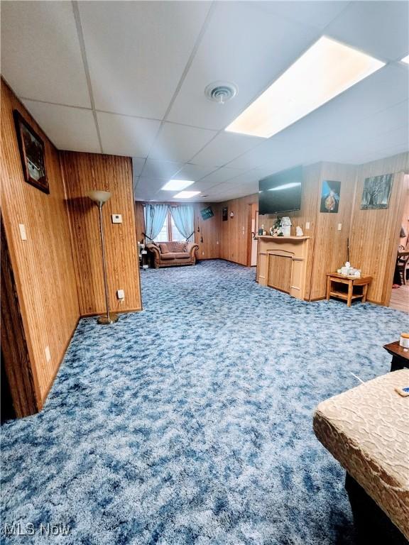 bonus room featuring carpet flooring and wood walls