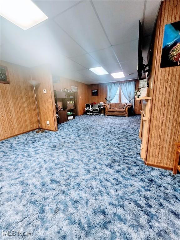 interior space featuring carpet flooring and wood walls