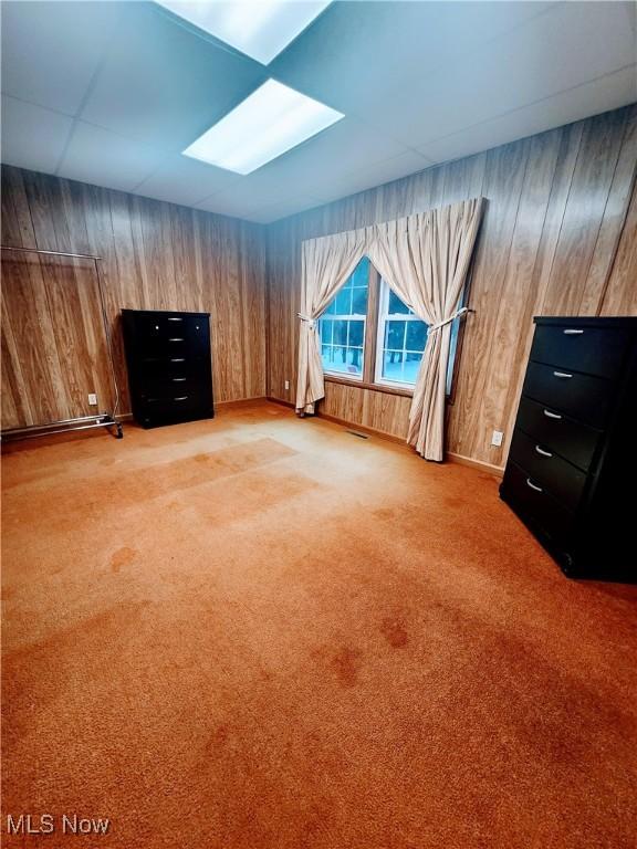 additional living space featuring carpet floors and wooden walls