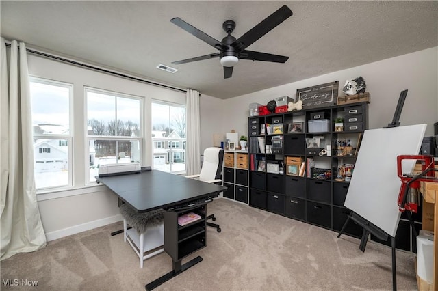 carpeted office featuring ceiling fan, a healthy amount of sunlight, and a textured ceiling