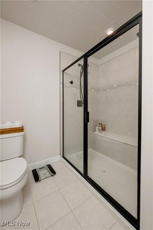 bathroom featuring toilet, tile patterned flooring, a textured ceiling, and walk in shower