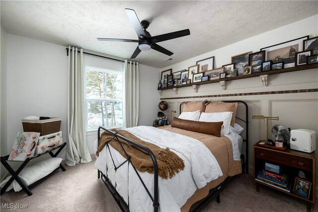 carpeted bedroom with ceiling fan and a textured ceiling