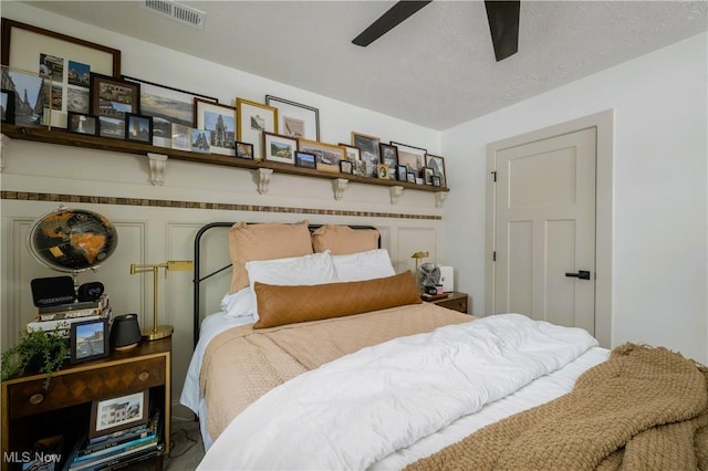 bedroom with ceiling fan and a textured ceiling