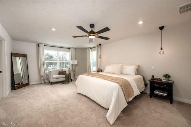 bedroom with carpet flooring, ceiling fan, and a textured ceiling