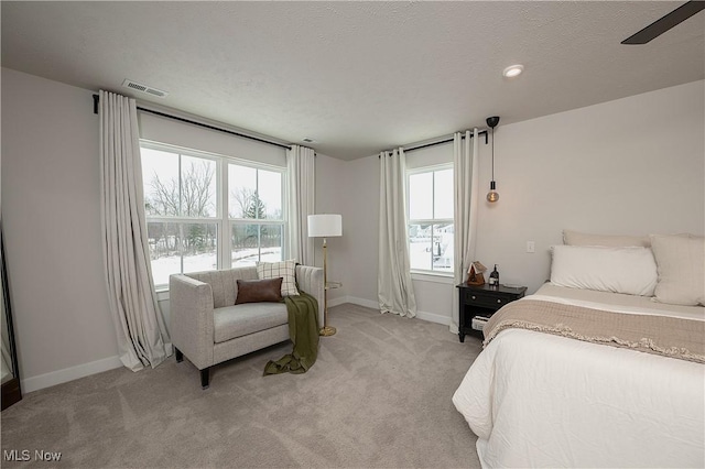 carpeted bedroom featuring ceiling fan and a textured ceiling