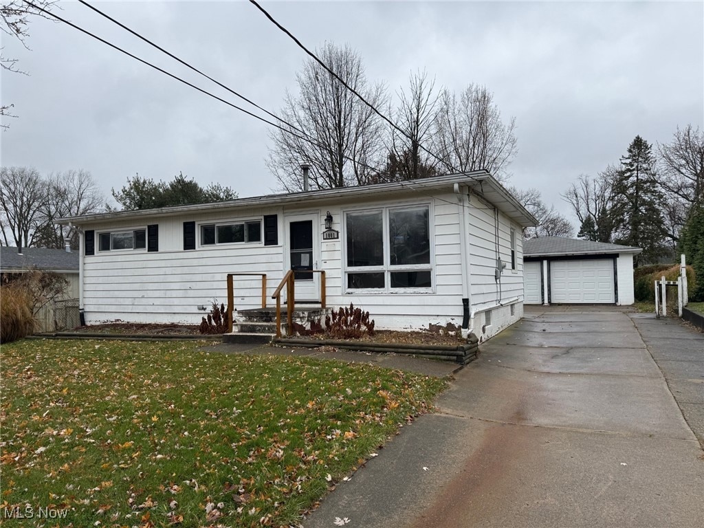 view of front of home with a garage, an outdoor structure, and a front yard