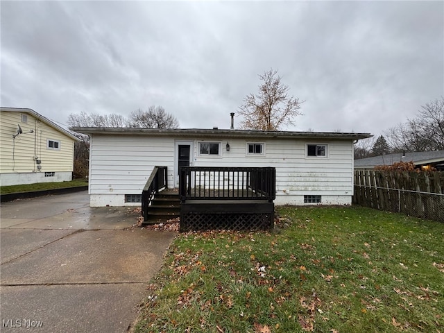 rear view of house featuring a yard and a deck