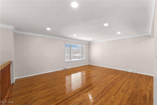 spare room with hardwood / wood-style flooring and ornamental molding