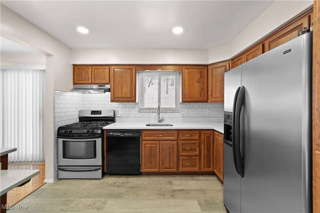 kitchen featuring stainless steel appliances, light hardwood / wood-style flooring, tasteful backsplash, and sink