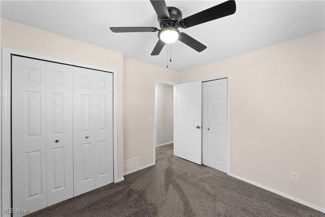 unfurnished bedroom featuring ceiling fan and dark carpet