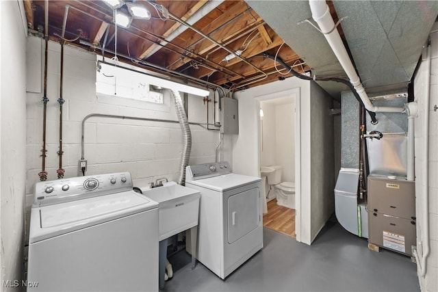 laundry room featuring washing machine and dryer, electric panel, and heating unit