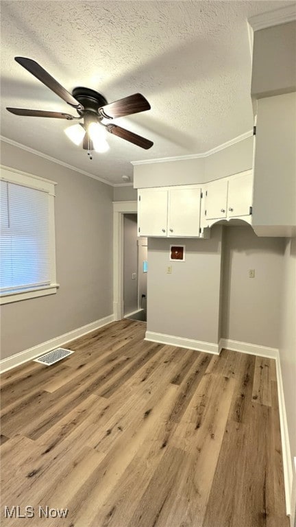 clothes washing area with crown molding, ceiling fan, and light hardwood / wood-style floors