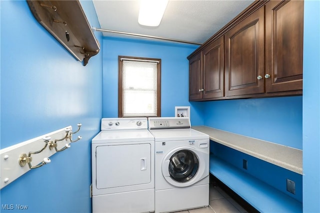 laundry area featuring cabinets, separate washer and dryer, and light tile patterned flooring