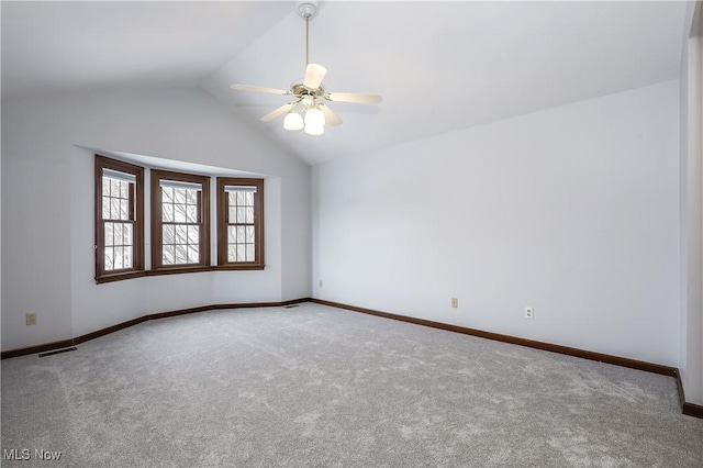 spare room with carpet, vaulted ceiling, and ceiling fan