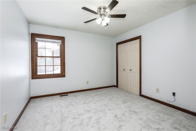 empty room with ceiling fan and light colored carpet