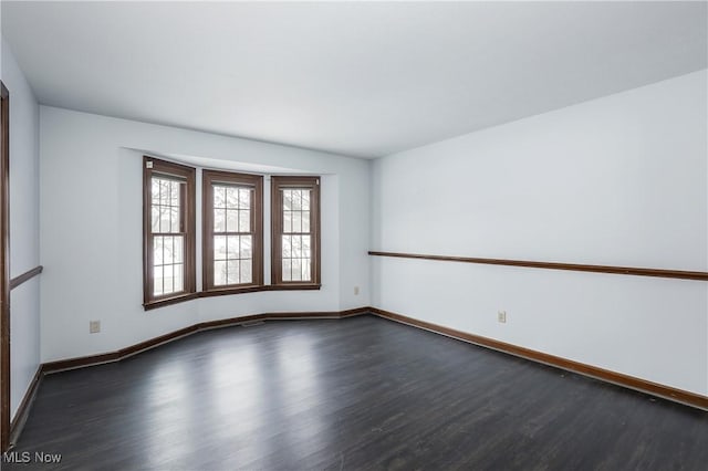 empty room with dark hardwood / wood-style flooring