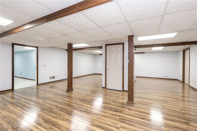 basement featuring wood-type flooring and a drop ceiling