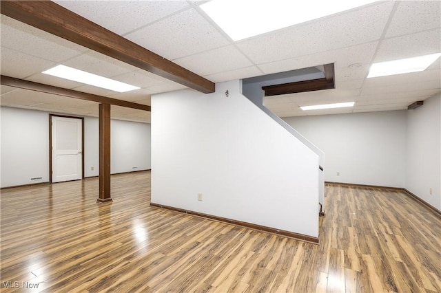 basement featuring a drop ceiling and wood-type flooring