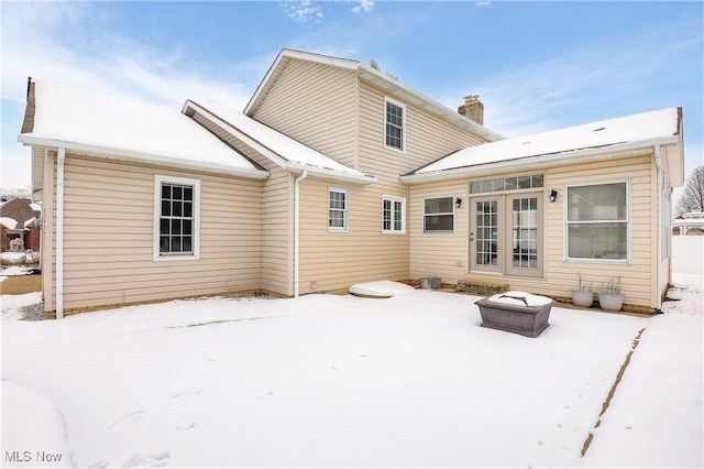 view of snow covered back of property