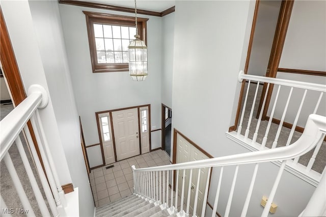 tiled foyer featuring crown molding