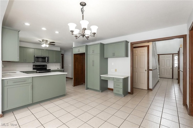 kitchen featuring gas stove, decorative light fixtures, and green cabinets