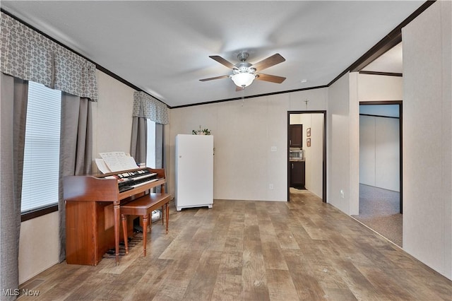 interior space with ornamental molding, ceiling fan, light hardwood / wood-style flooring, white fridge, and lofted ceiling