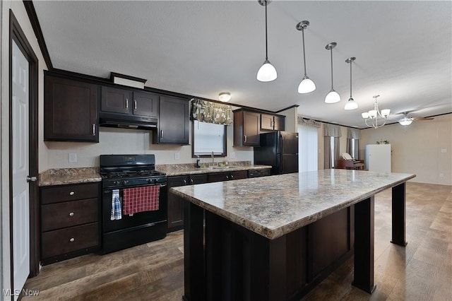 kitchen with dark brown cabinets, sink, black appliances, a center island, and hanging light fixtures