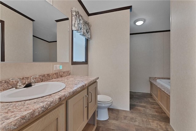 bathroom with a tub to relax in, vanity, crown molding, hardwood / wood-style flooring, and toilet