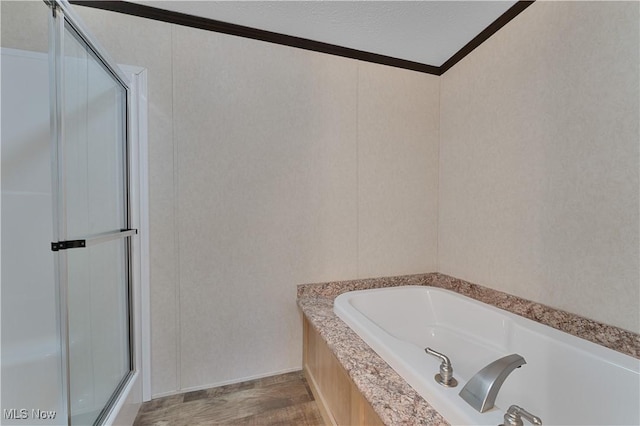 bathroom featuring a bathing tub, hardwood / wood-style floors, a textured ceiling, and crown molding