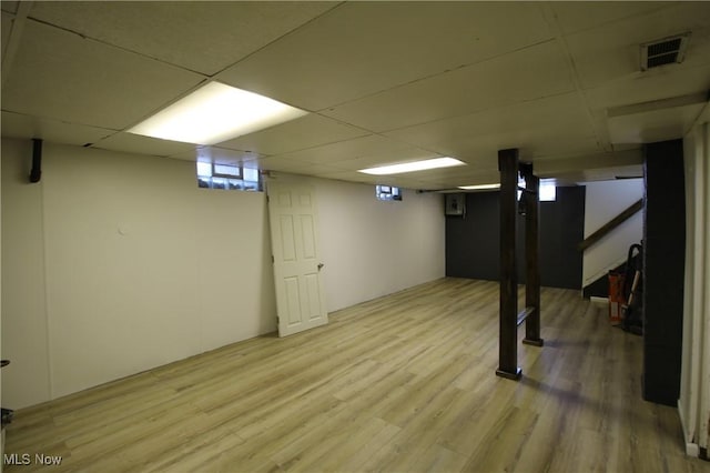 basement with light hardwood / wood-style floors and a drop ceiling