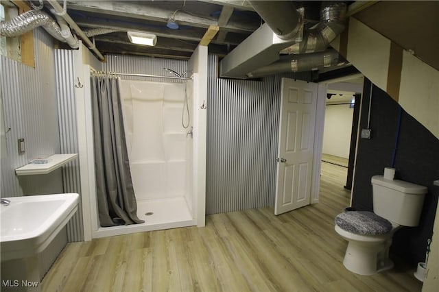 bathroom featuring a shower with shower curtain, wood-type flooring, and toilet