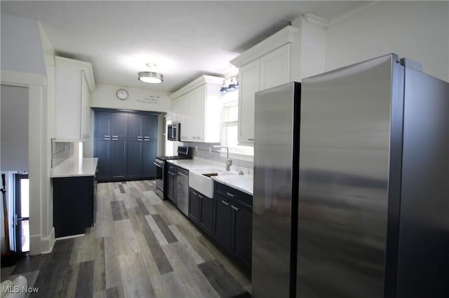 kitchen with dark wood-type flooring, sink, white cabinets, and stainless steel appliances