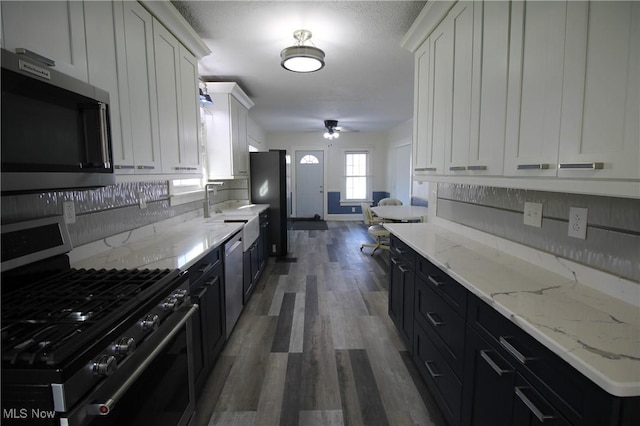 kitchen with white cabinets, decorative backsplash, dark hardwood / wood-style flooring, and stainless steel appliances