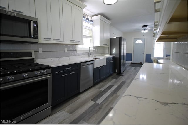 kitchen featuring sink, white cabinets, stainless steel appliances, and plenty of natural light