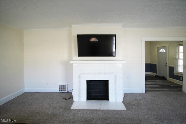 unfurnished living room with crown molding, a fireplace, a textured ceiling, and dark colored carpet