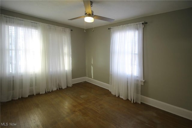 spare room with dark hardwood / wood-style flooring, plenty of natural light, and ceiling fan