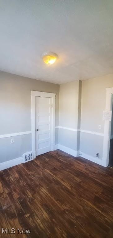 unfurnished room featuring dark wood-type flooring