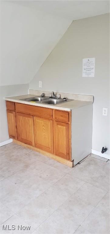 kitchen featuring lofted ceiling and sink