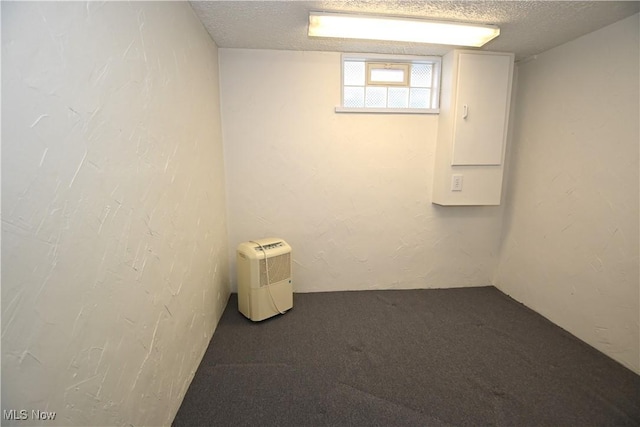 carpeted empty room featuring a textured ceiling