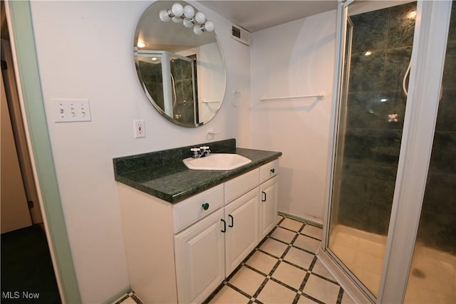 bathroom with tile patterned flooring, vanity, and a shower with door