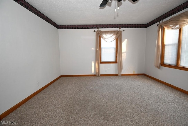 carpeted empty room featuring ceiling fan and a textured ceiling