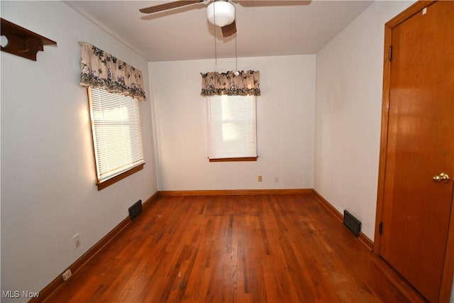 unfurnished room featuring ceiling fan and dark wood-type flooring