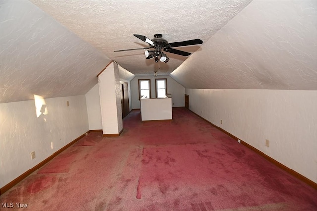 bonus room featuring carpet flooring, a textured ceiling, vaulted ceiling, and ceiling fan