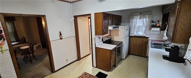 kitchen featuring electric stove, dark brown cabinets, extractor fan, and sink